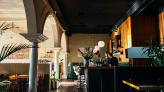 Two managers at restaurant POS by bar in grand restaurant