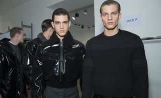 Male models wearing a comfortable dark gray sweater and stylish black jacket from A/W 2015 Calvin Klein Collection.