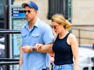 Blake Lively and Ryan Reynolds walk together wearing sunglasses