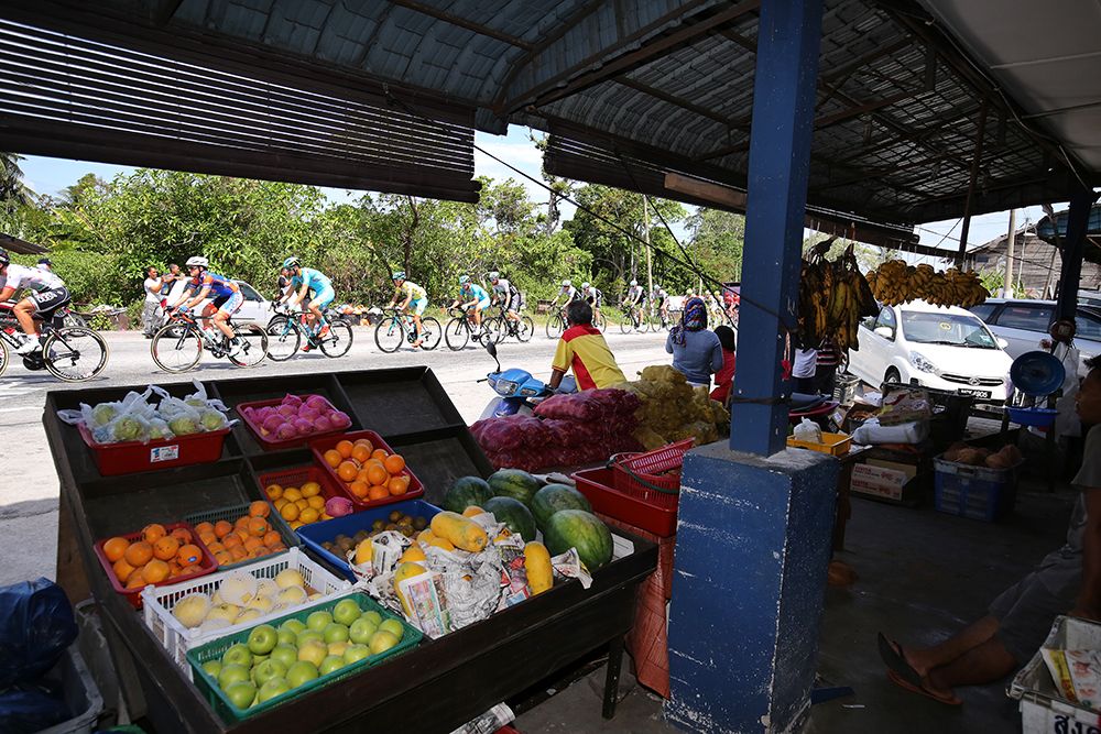 The riders pass a fruit stand