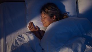 A woman sleeping happily in a dark room
