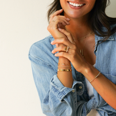 Woman wearing denim shirt and gold jewelry