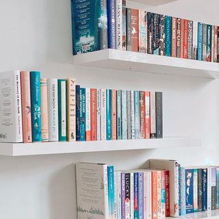 Three floating bookshelves with books on them