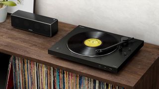 Sony PS-LX310BT turntable on a side table accompanied by a black Sony speaker