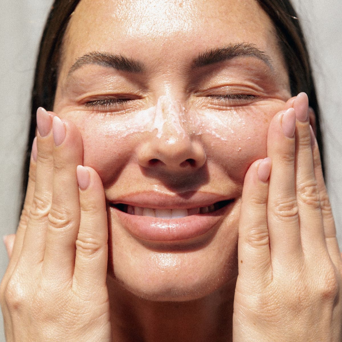 An image of a woman washing her face.
