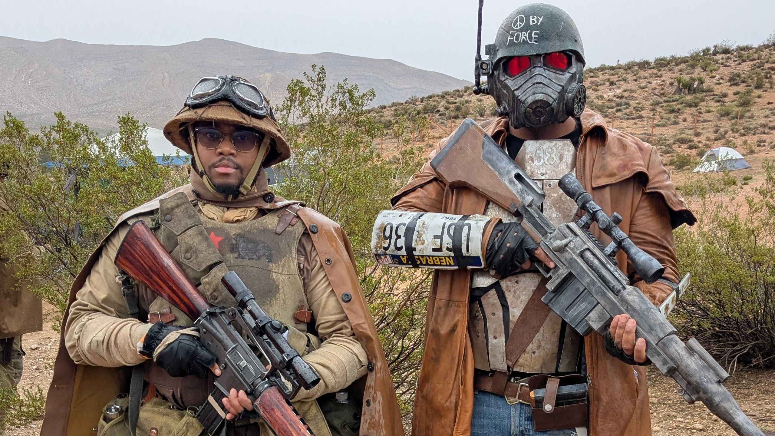 Two individuals dressed as Fallout: New Vegas soldiers, an NCR grunt holding an assault rifle, and a gas mask Ranger carrying a sniper rifle.