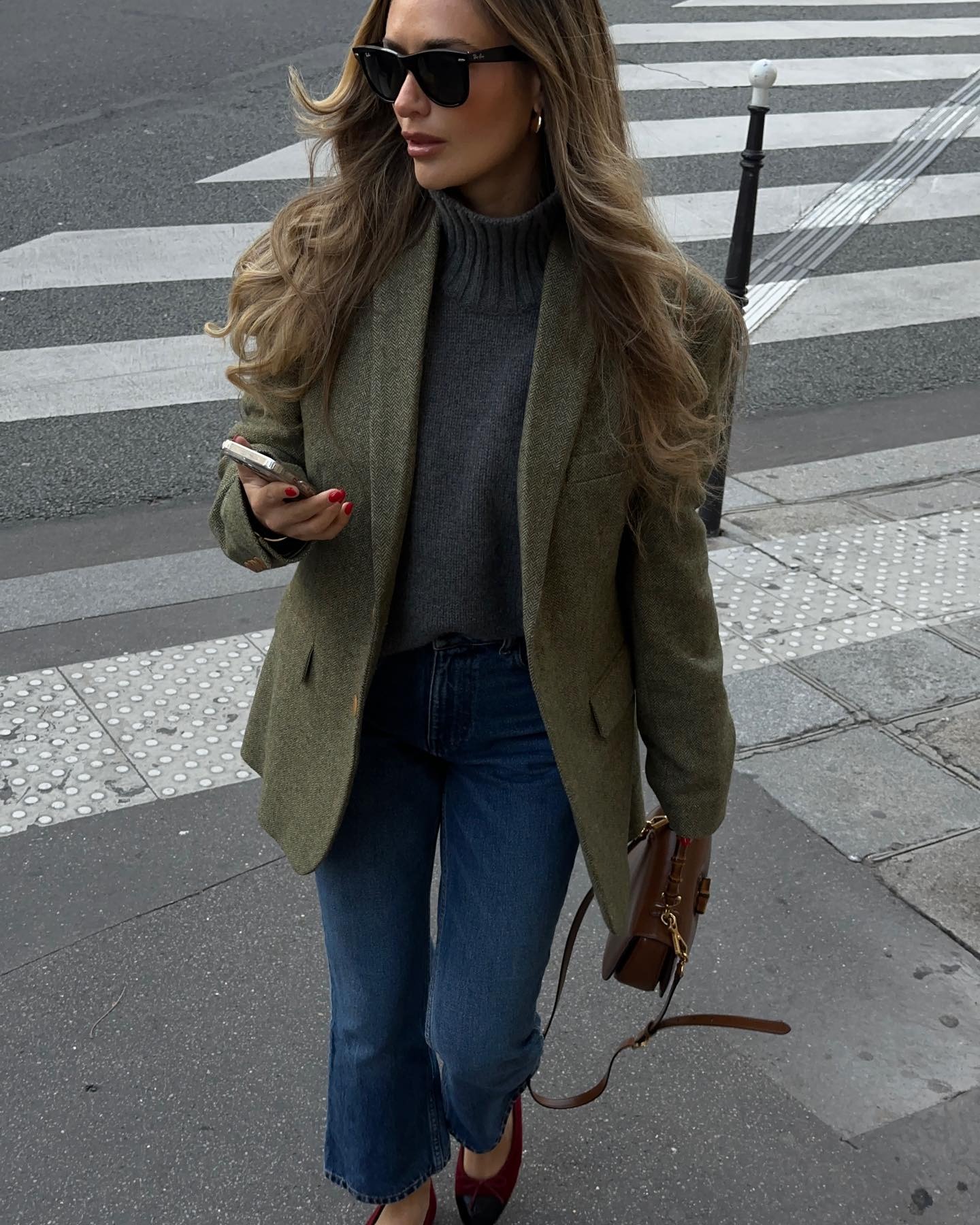Woman in olive green blazer and charcoal gray sweater