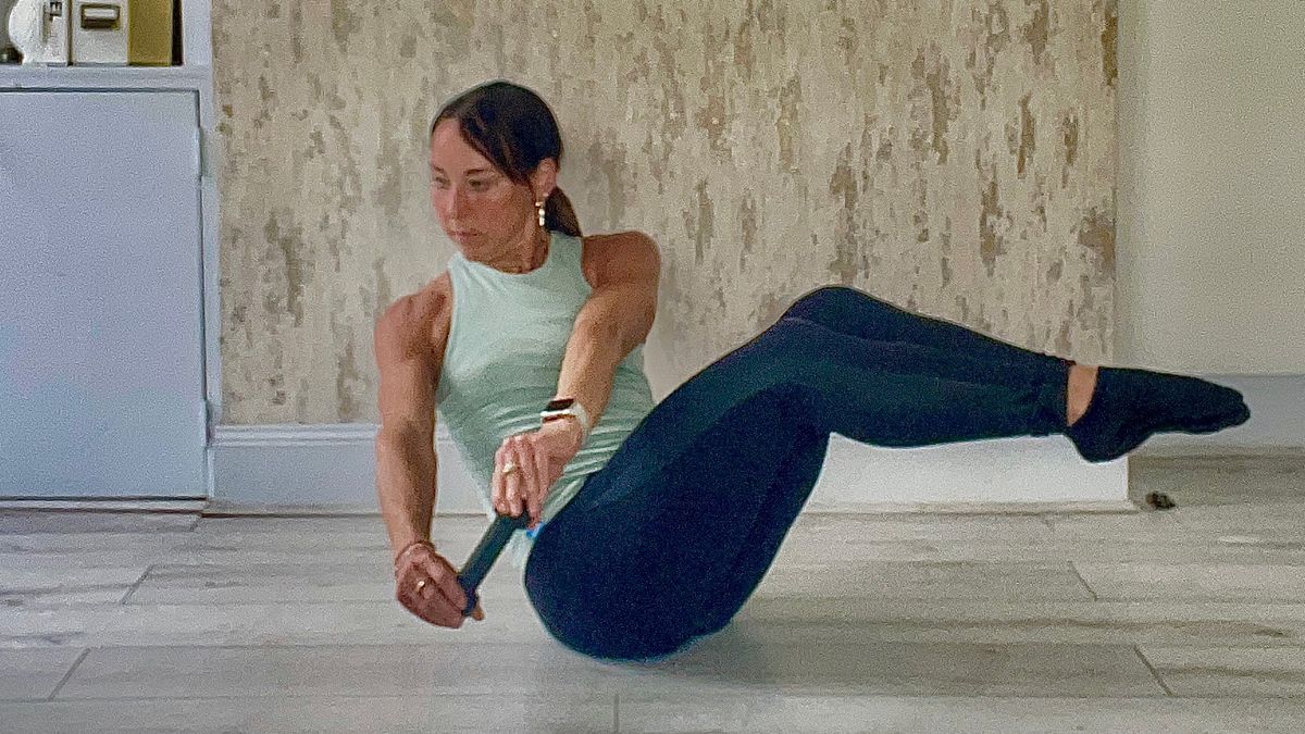 Lucy Miller performing seated Russian twists with dumbbell