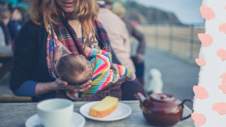 Woman breast feeding a baby outside with tea and cake