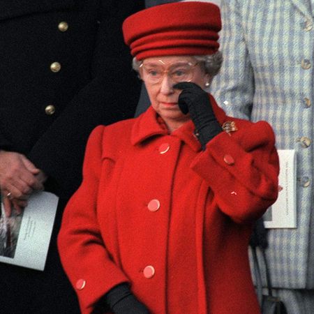 Queen Elizabeth wearing a red coat crying