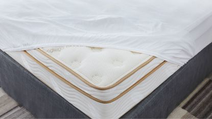 Mattress pad vs mattress topper: a Saatva mattress protector and topper on bed 