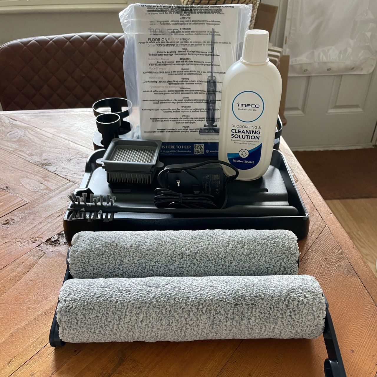 Accessories of the Tineco FLOOR ONE S5 Smart Mop sitting on a wooden table