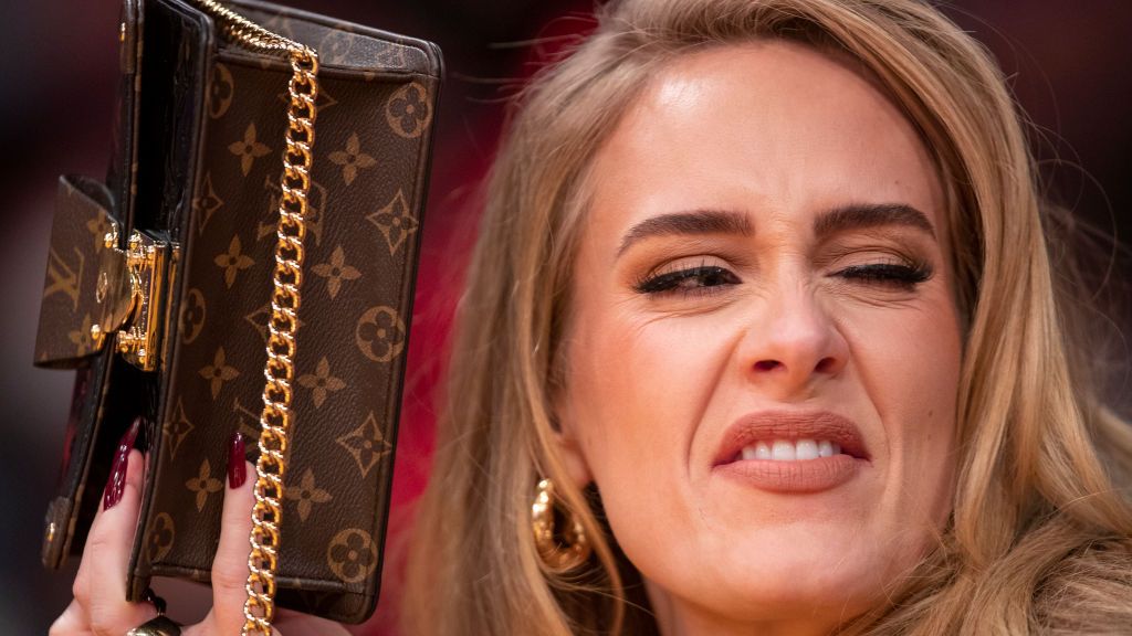 los angeles, ca october 19 singer adele uses her purse to hide from the tv camera while she sings along to her song being played to the audience while attending a game between the golden state warriors and the los angeles lakers on october 19, 2021 at staples center in los angeles allen j schaben los angeles times via getty images
