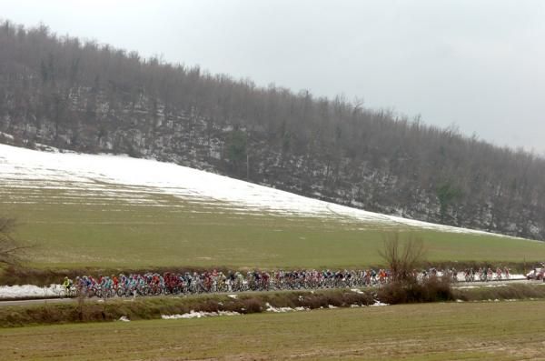 The peloton passes what's left of the winter snow on the road to Macerata.