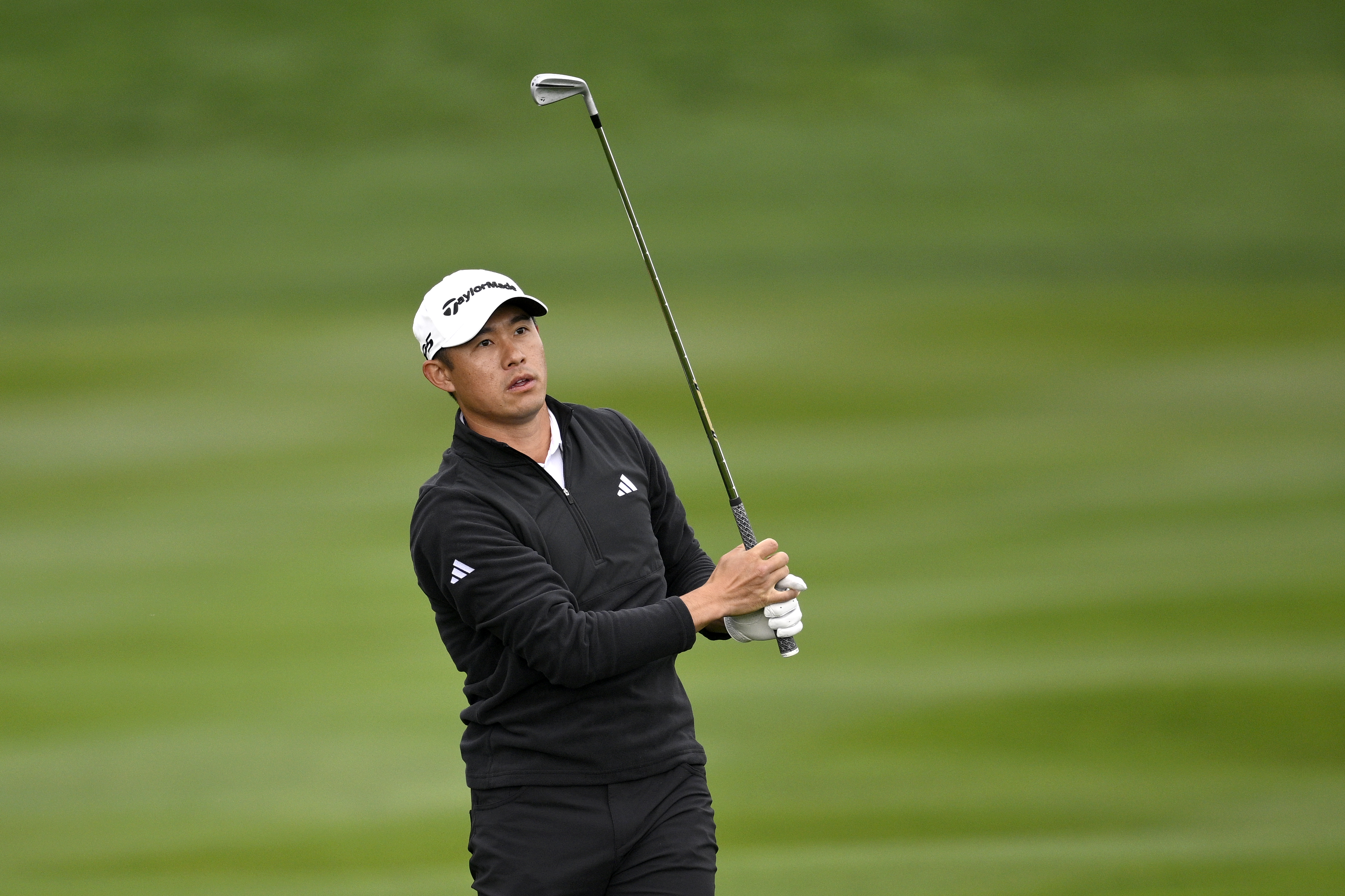 Collin Morikawa hits an iron into the green