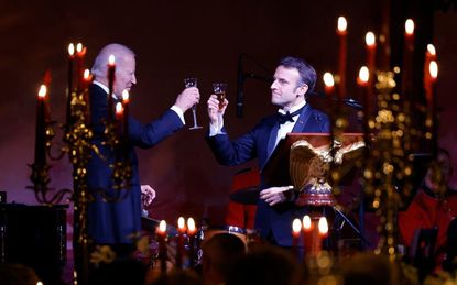 Biden and Macron clinking glasses.