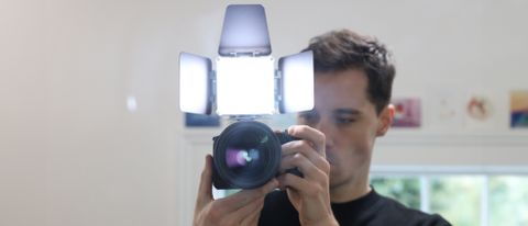 Zhiyun FIVERAY M20C LED panel mounted on a camera and held in front of a man's face