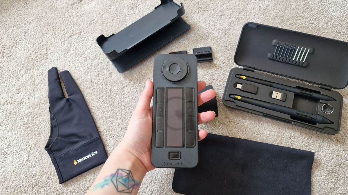 A photo of the Xencelabs Quick Keys being held above a collection of other tablet accessories