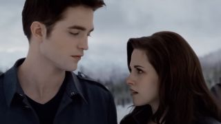 Edward and Bella looking at each other in a snowy forest in The Twilight Saga: Breaking Dawn Part 2