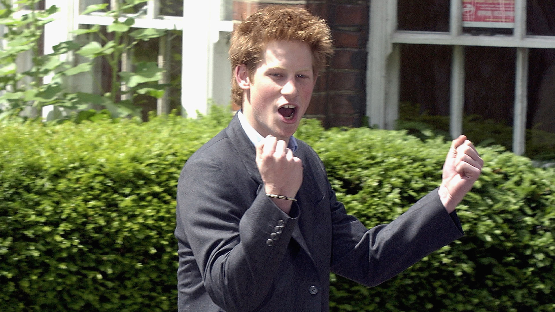 WINDSOR, ENGLAND - JUNE 12: (FILE PHOTO) Prince Harry clenches his fist as he leaves Eton College on June 12, 2003 in Windsor, England. The Royal Family on October 9, 2004 denied allegations that the Prince had cheated in his art A-level. Sarah Forsyth, a former teacher of Harry at Eton, made the allegations as she prepared to take the college to an industrial tribunal claiming unfair dismissal. (Photo by Anwar Hussein/Getty Images) 