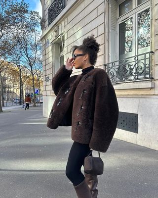 Influencer wears a brown suede bag.