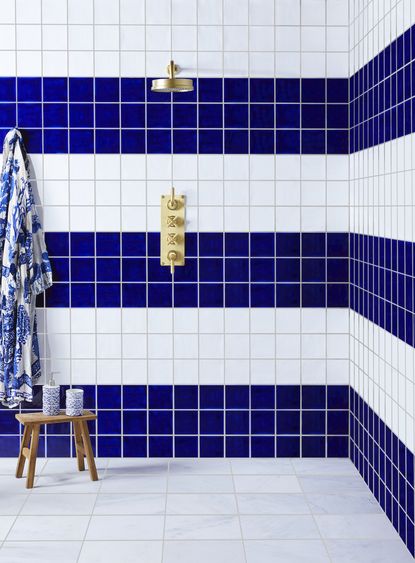 shower tile ideas with a blue and white tiled shower and brass taps and head