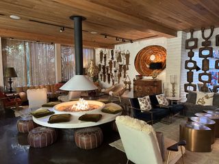 The lobby at Parker Palm Springs with macrame owl wall art and an indoor fire pit