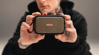 Man holds up Positive Grid Spark Go amp to the camera