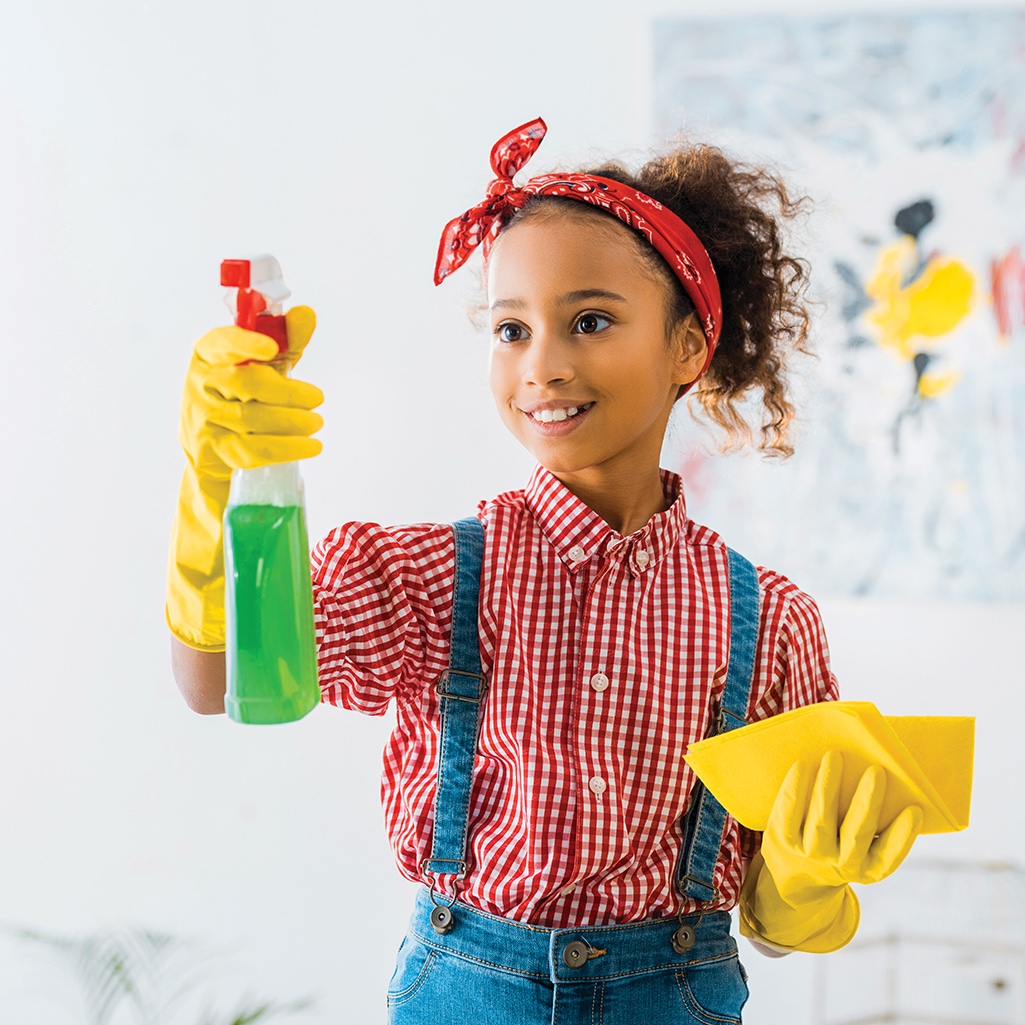 Young girl holding up cleaning products
