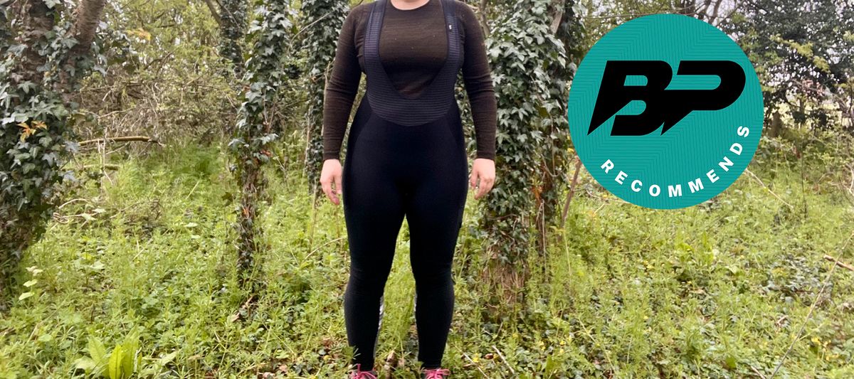 A woman in cycling kit standing in the woods