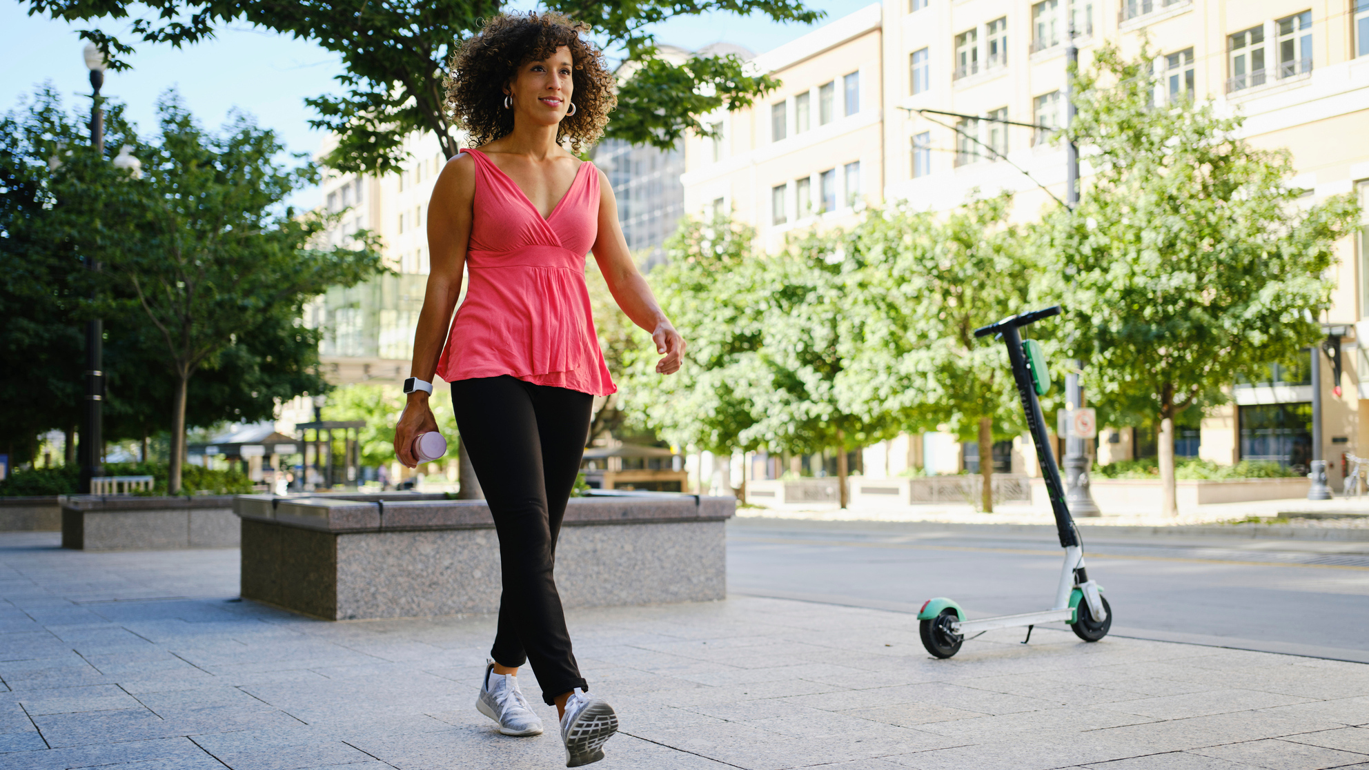 Woman walking in city on sunny day