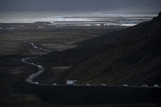 vehicles leaving the town of Grindavik, southwestern Iceland, during evacuation following earthquakes., with the sea in the background
