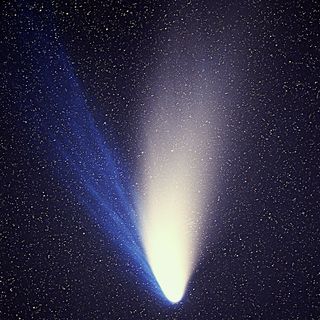 The very bright Comet C/1995 O1, better known as Comet Hale-Bopp, delighted skywatchers worldwide in 1997 with its dual tails — one of blue-glowing ions, and the other of dusty particles reflecting sunlight. Image by E. Kolmhofer at al.