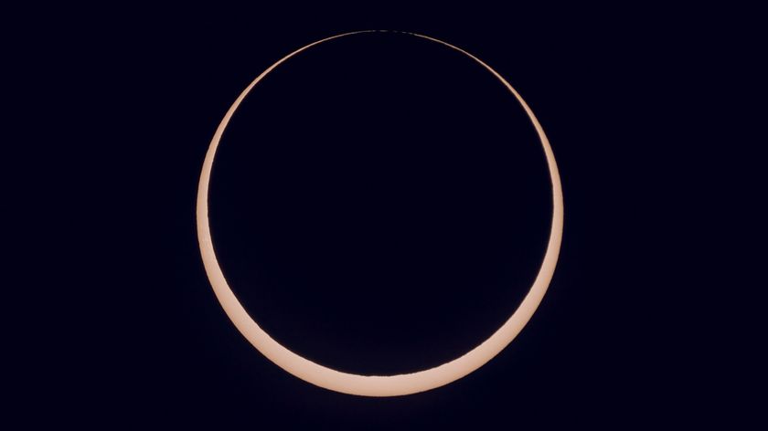 the sun is partially blocked by the moon during annular solar eclipse and appears as a glowing orange ring of light.