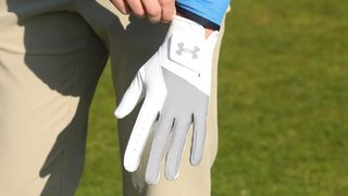 A man adjusts the Under Armour Medal Glove strap