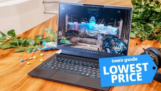 Alienware x14 shown on table with plant, candy, and headset