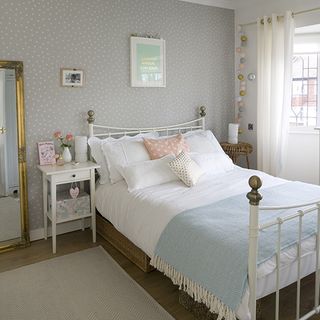 bedroom with grey wallpaper and wooden flooring