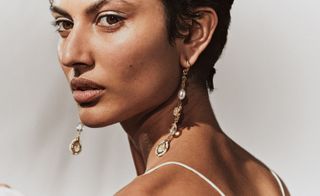 Model wears long earrings, part of Goossens bridal jewellery