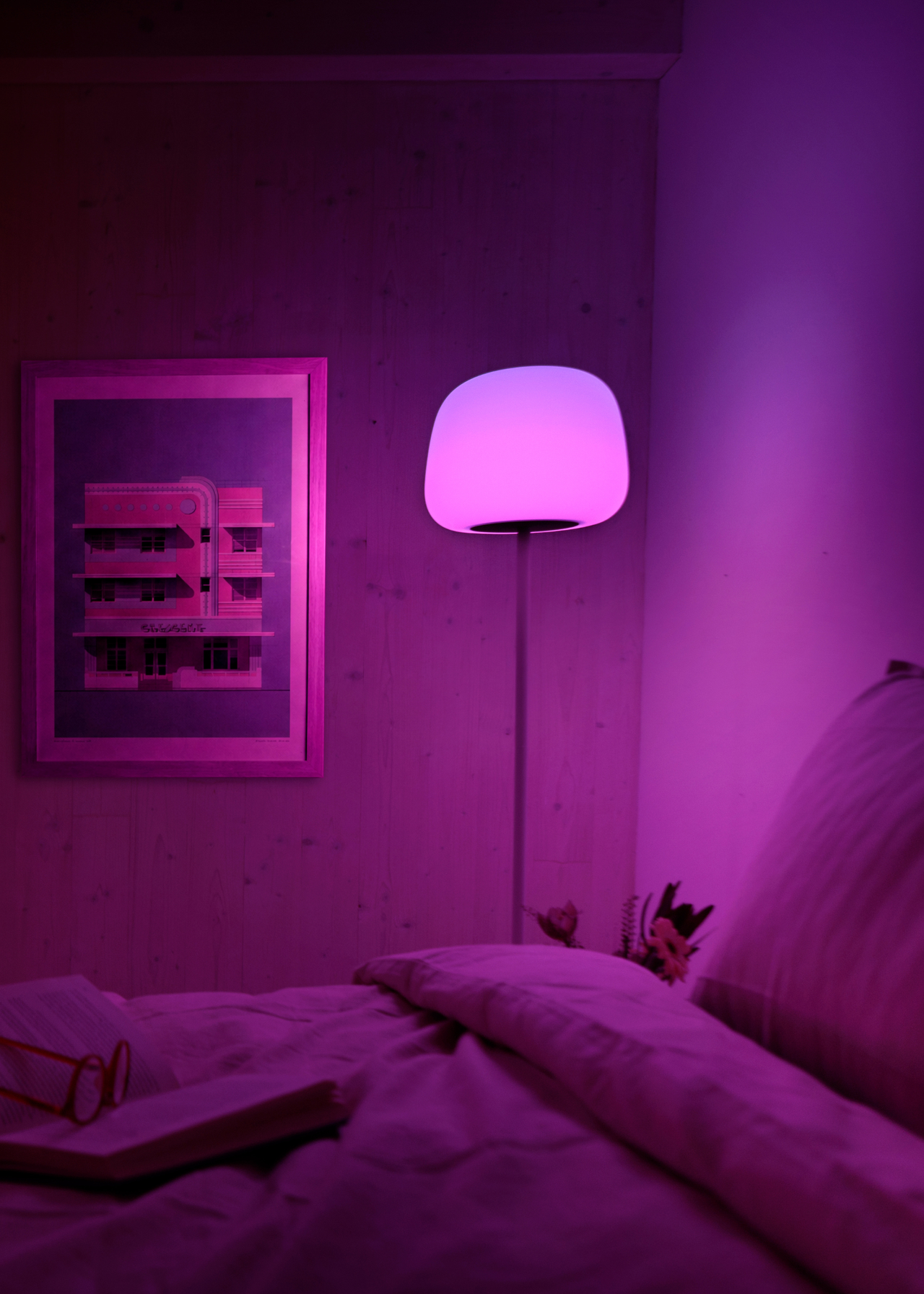 A purple lamp in a bedroom by night
