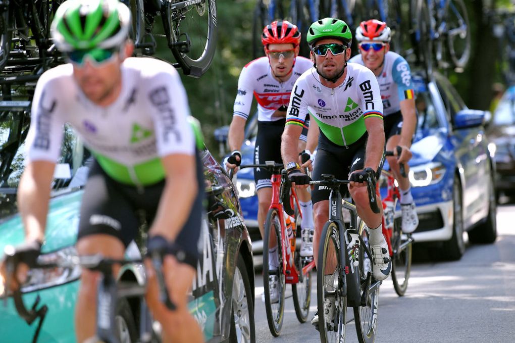 Mark Cavendish rides in the cars after a flat tyre during stage 2 in Poland
