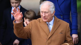 King Charles III waves as he departs after attending the Christmas morning church service on December 25, 2023