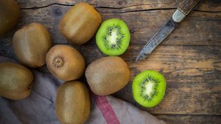 Collection of kiwi on a table next to knife