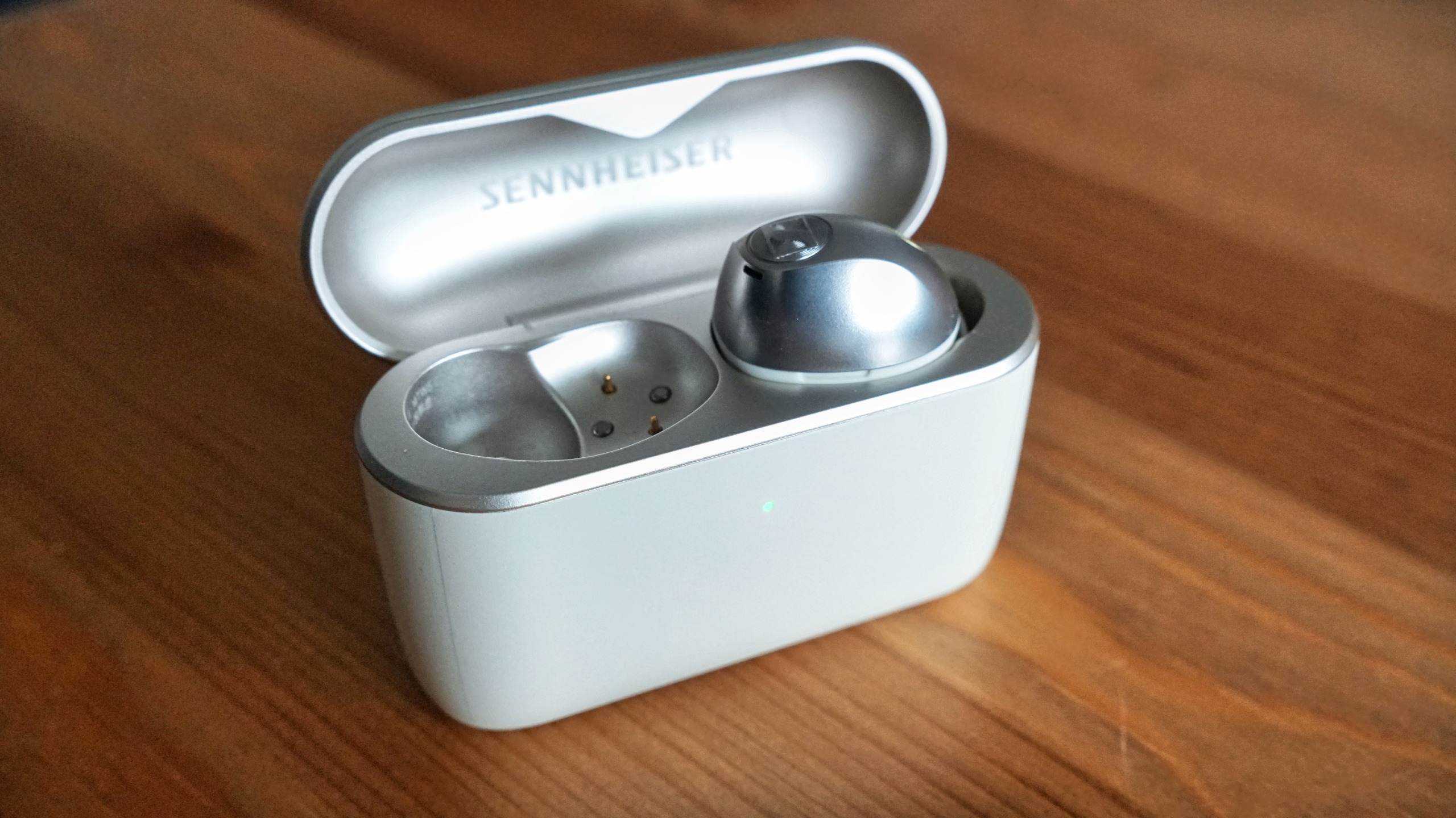 Sennheiser Momentum True Wireless 5 in white, showing details of the buds held in a hand