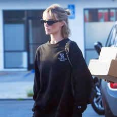 Margot Robbie wearing a sweatshirt, leggings, crew socks, and chunky sneakers