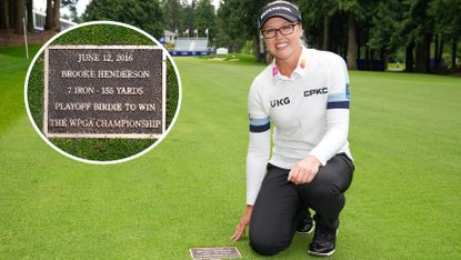Brooke Henderson poses by her plaque on the 18th hole at Sahalee