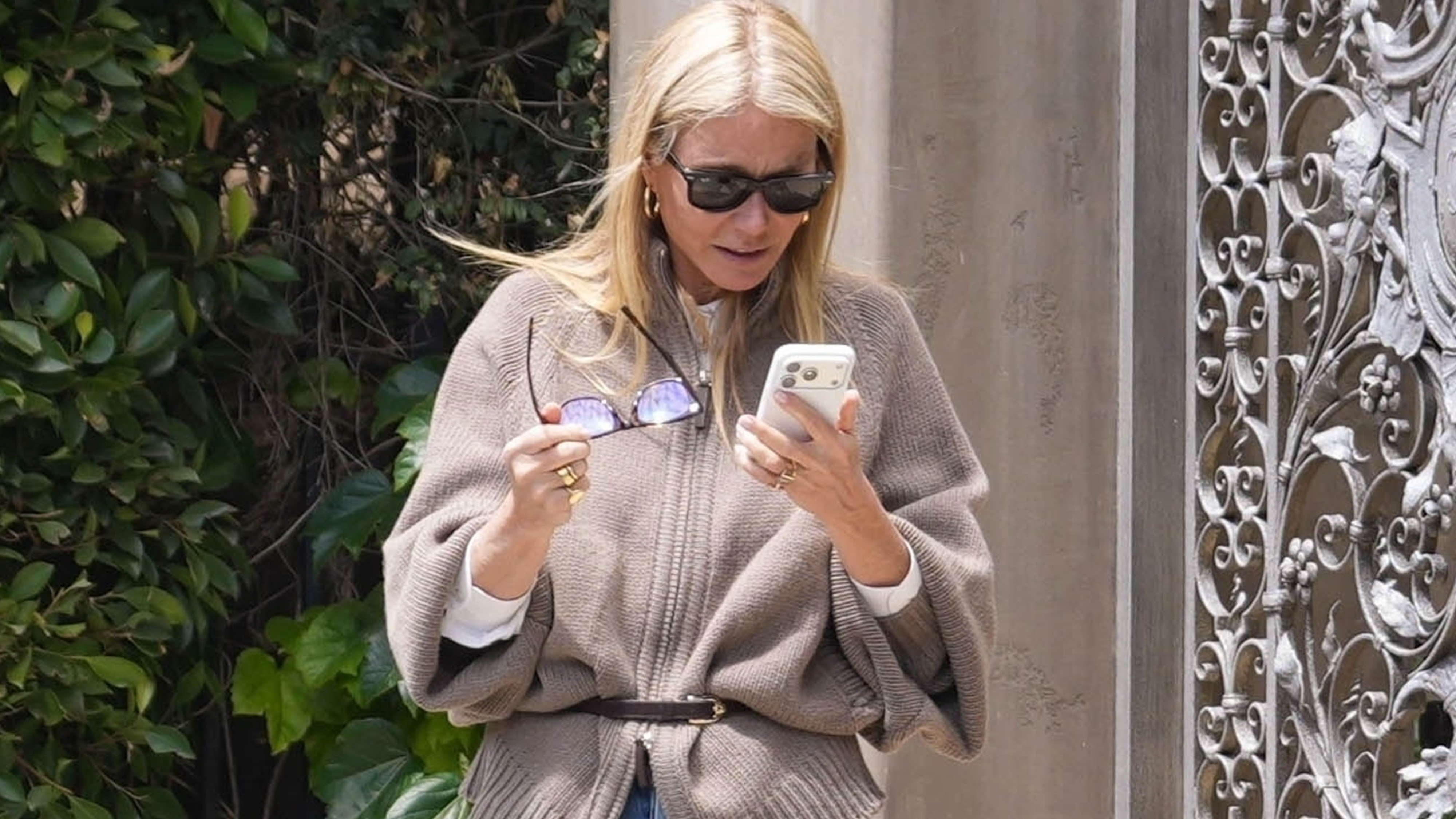 Actress Gwyneth Paltrow attending Jennifer Meyer's baby shower in Los Angeles wearing a belted cardigan, vintage jeans, and kitten-heel sandals.