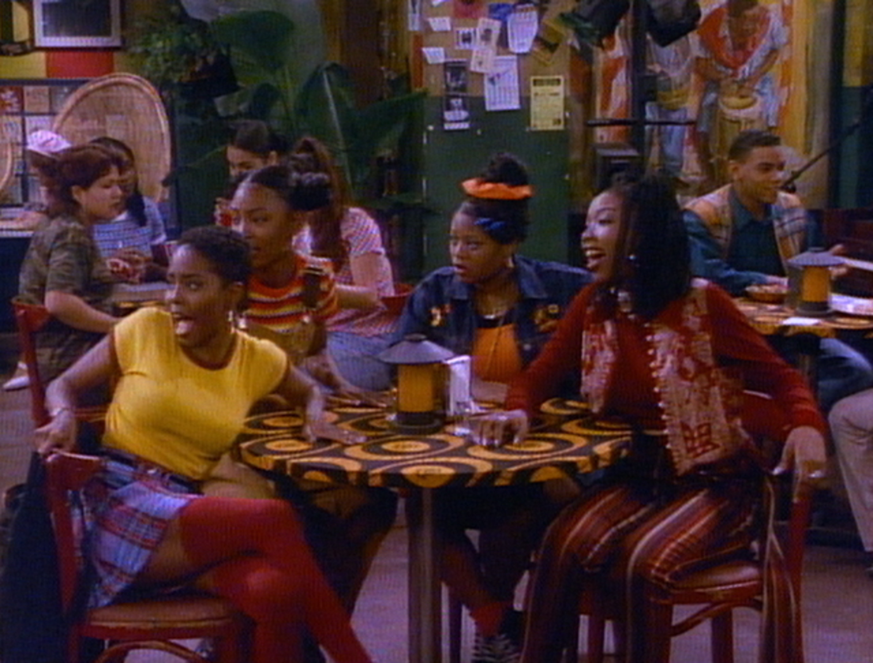 The cast of Moesha, staring off screen in shock at at restaurant