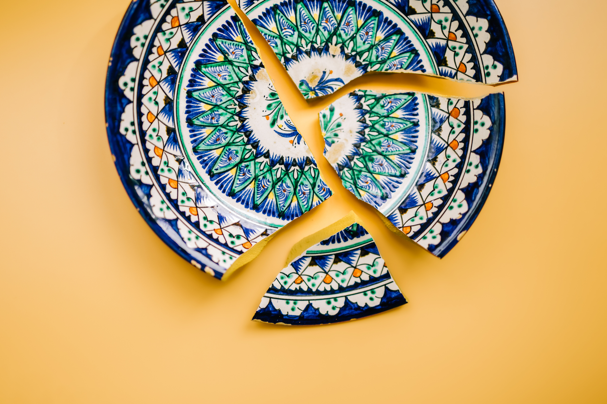 A decorative plate broken into several pieces.