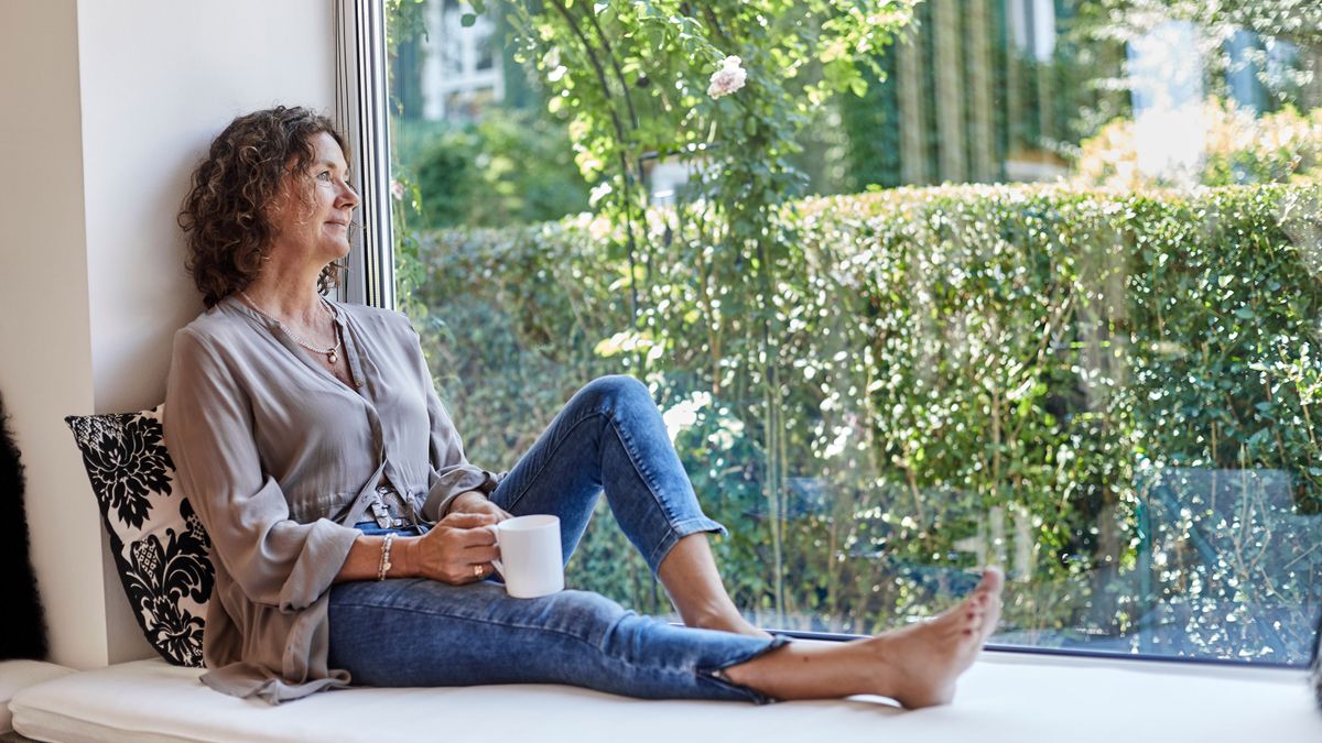 woman in picture window looking at view