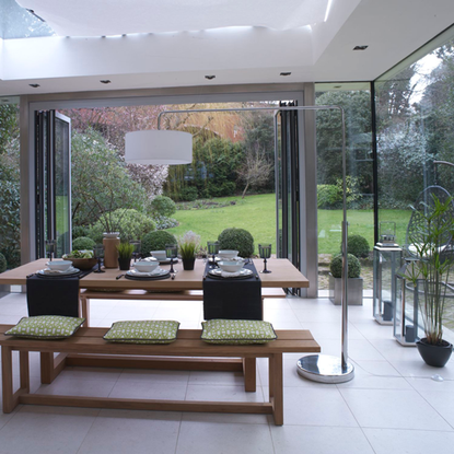 living room with dinning table with bench and white flooring with glass partition